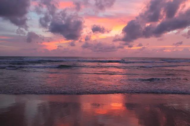 Sunset at Karon beach, Phuket - pink sky reflected on the wet sand and waves