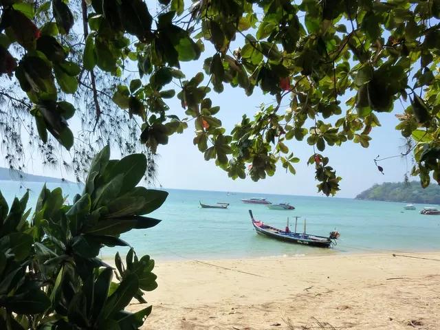 Traditional longtail boat in the shallow bay of Rawai beach, Phuket