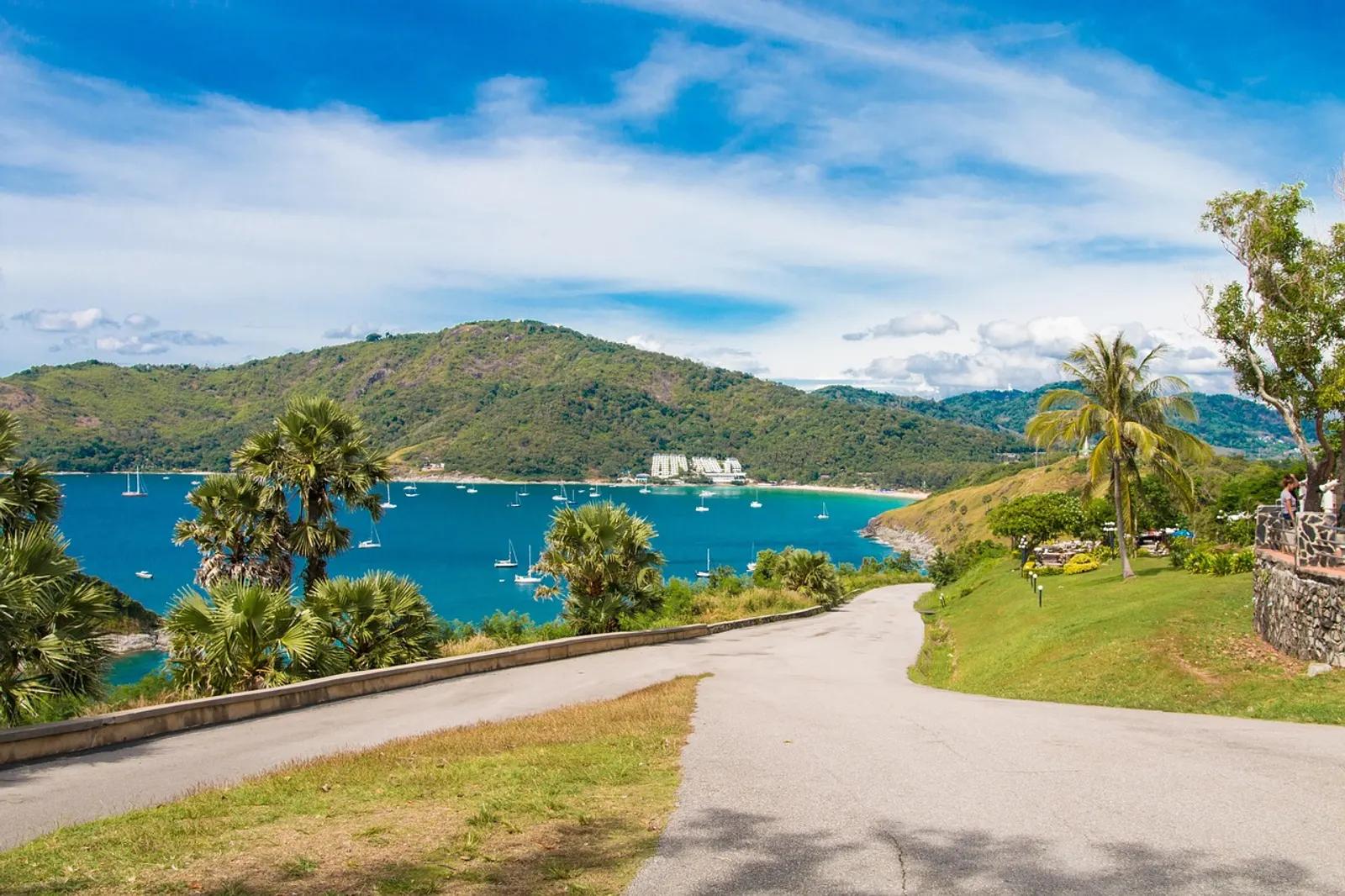 View over the southern Phuket coastline with palms, green hills and a yacht-filled bay