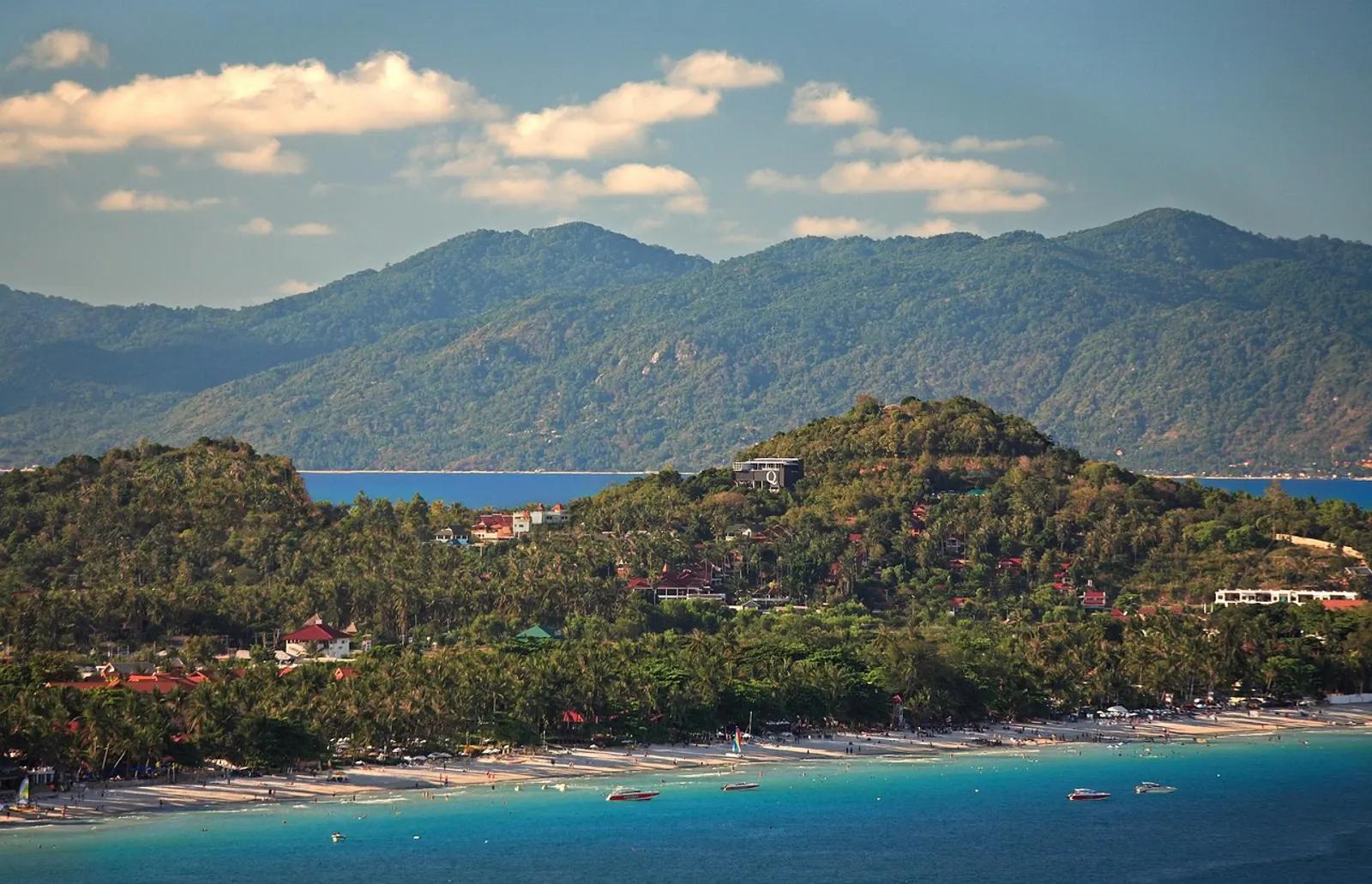 Aerial view of the Koh Samui coastline with palm groves and sandy beach