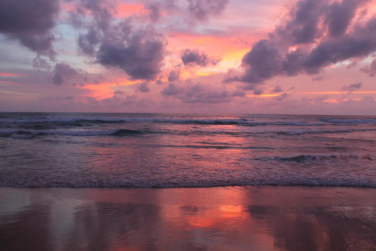 Sunset at Karon beach, Phuket - pink sky reflected on the wet sand and waves